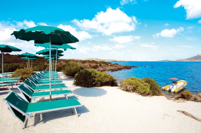 Spiaggia con lettini verdi e ombrelloni, vista su mare azzurro.