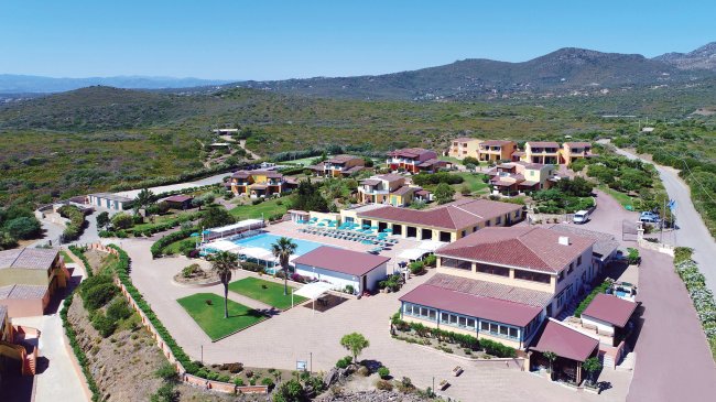 Veduta aerea di un complesso con piscina circondato da colline.