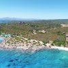 Costa rocciosa con vegetazione e acque turchesi, vista dall'alto.