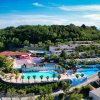 Grande parco acquatico con piscine e vegetazione lussureggiante.
