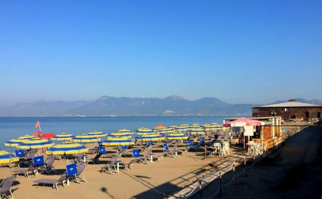 Spiaggia con ombrelloni gialli e blu.