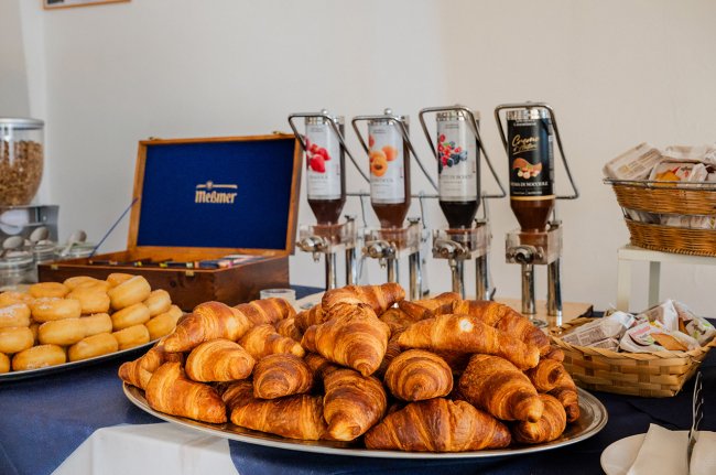 Un vassoio di croissant e dispenser di marmellata.