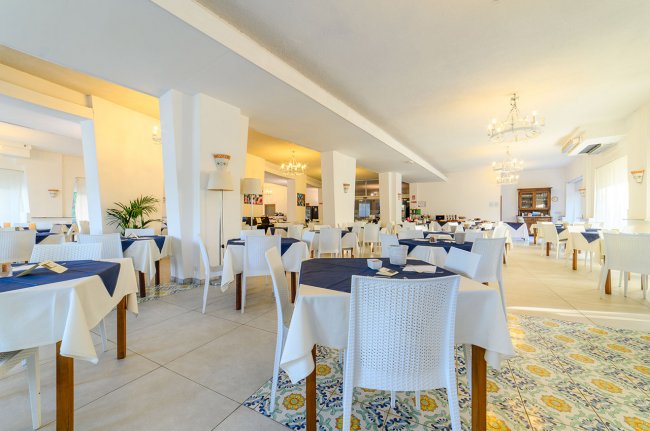 Ristorante elegante con tavoli apparecchiati e lampadari.