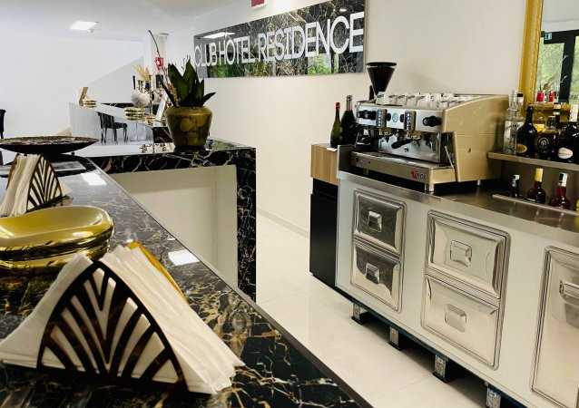 Macchina del caffè e bar in marmo scuro.