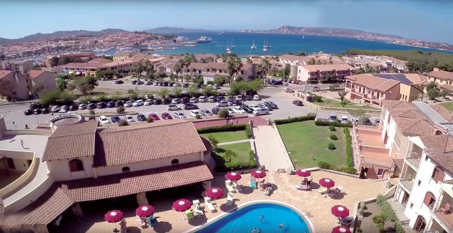 Vista su un complesso alberghiero con piscina e vista sul mare.