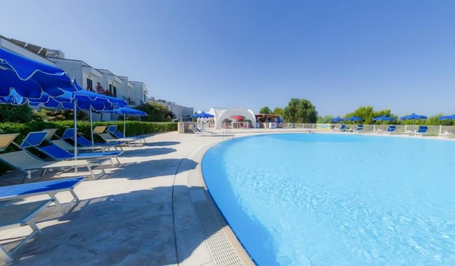 Piscina con lettini e ombrelloni.