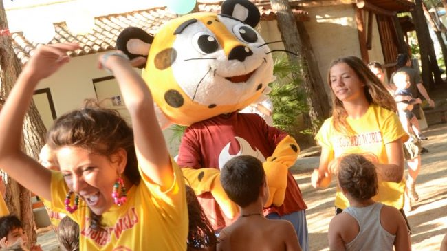 Persone ballano con un personaggio in costume di tigre.