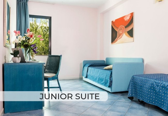 Junior suite con divano letto, scrivania e finestra panoramica.