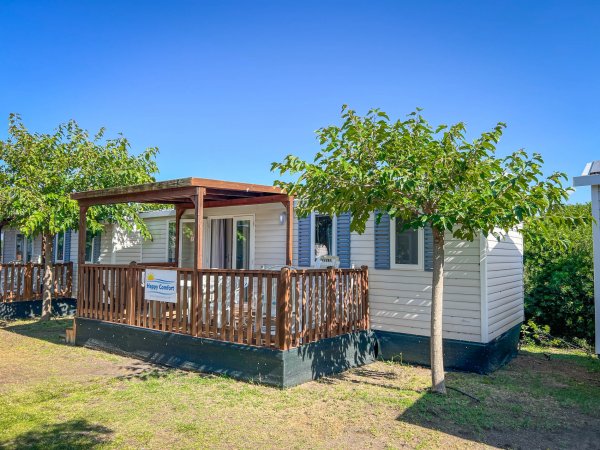 Casa mobile con veranda e alberi.