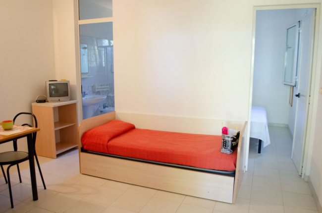 Stanza semplice con letto singolo e TV.