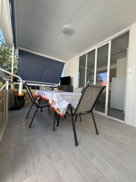 Veranda con tavolo apparecchiato e sedie.