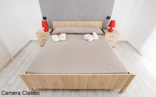 Letto matrimoniale con due lampade rosse.