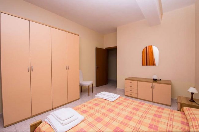Camera da letto con armadio e letto a quadri.