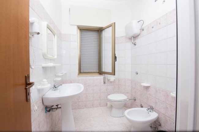 Bagno con sanitari e finestra aperta.