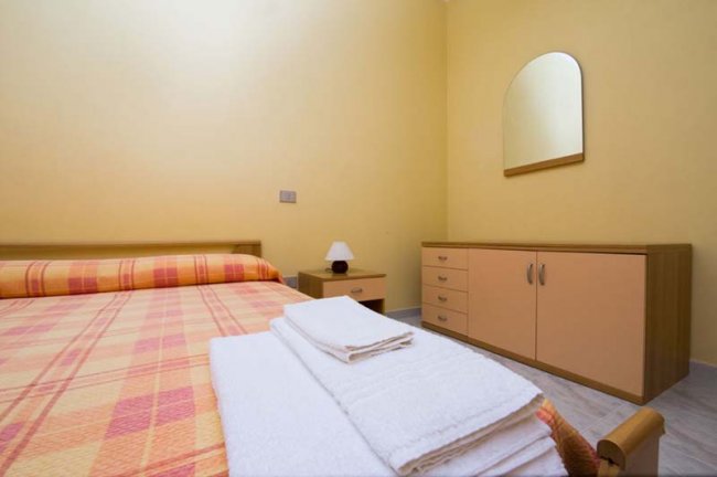 Camera con letto matrimoniale e comò.