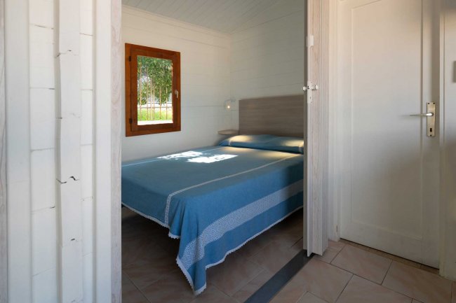 Camera da letto con letto matrimoniale e finestra.