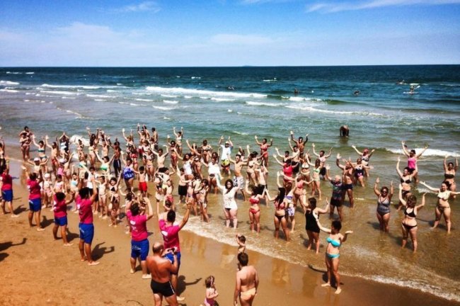 Persone che fanno esercizi sulla spiaggia.
