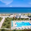 Piscina vicino a una spiaggia con il mare sullo sfondo.
